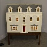 A large dolls house, modelled as a Georgian town house, with wired electric lights and a large