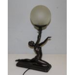 A modern figural electric table lamp, in The Art Deco style, with semi-nude female figure holding