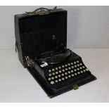 A vintage Remington Home Portable Typewriter, wear to cloth covered case.