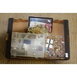 Three plastic trays containing various costume jewellery, brooches, bead necklaces and clip-on