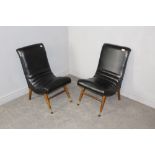 A pair of mid-century black leatherette cocktail chairs, of scrolling form, tapering legs with metal