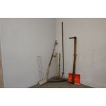 A vintage scythe, cross-cut saw, pickaxe and aother miscellaneous garden tools.