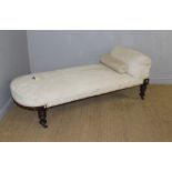 A Victorian mahogany framed chaise longue or day bed, with sprung seat and padded back raised on