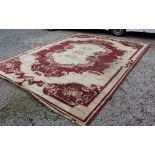 A large red and cream machine made carpet, of Persian design 470cm x 367cm some staining and