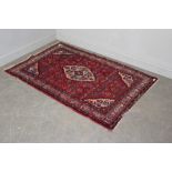 A Persian design rug, with central lozenge enclosed by a field of foliate motifs, spandrels and