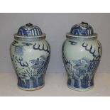 A pair of Chinese blue and white lidded urns, the domed covers with metal ring handles over baluster