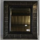 A silvered frame decorative mirror, the frame with repeating stylised foliate design 50cm x 44cm