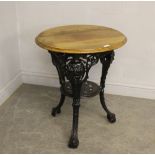 A black painted cast-iron Britannia bar table, with moulded circular mahogany top 71cm x 60cm Good