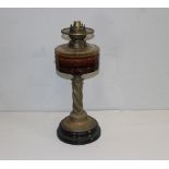 A Victorian brass and glass oil lamp, with brass burner over the amber glass reservoir and barley-