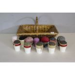 A woven-wicker trug and a selection of pin cushions