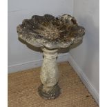 A cast composite stone bird bath, the scallop shell top over a baluster column 75cm x 51cm crack