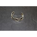 A white metal cuff bangle, five fused stylised oval links, marked 'NB A' 6.5cm good used condition.