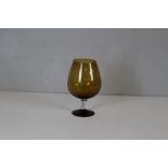 A mid century amber-glass oversized brandy glass with twisted stem 23cm high