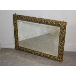 A large modern gilt-framed foliate moulded mirror, with bevelled plate 78cm x 108cm small loss to