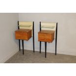 A apir of 1960's oak and ebonised bedside tables, the raised backs with glass shelf over two drawers