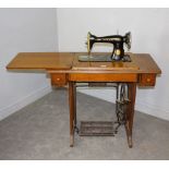 An oak and cast-iron treadle sewing machine EF87324 76cm x 117cm (extended) x 41cm used condition,