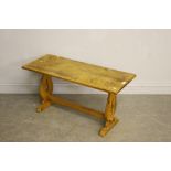 A pine refectory style coffee table, with oblong top over shaped and pierced supports linked by a