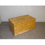 A pine trunk/bedding box, of rectangular form with hinged top, the moulded base with casters 48cm