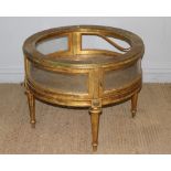 A circular gilt-wood display table, in the 19th century style, with bowed glazed door to the frieze,