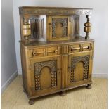 A reproduction oak court cupboard, of traditional form with foliate, linen-fold and barley-twist