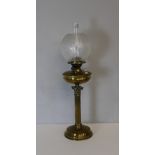 An early 20th century brass Corinthian column oil lamp, with etched globular glass shade over the