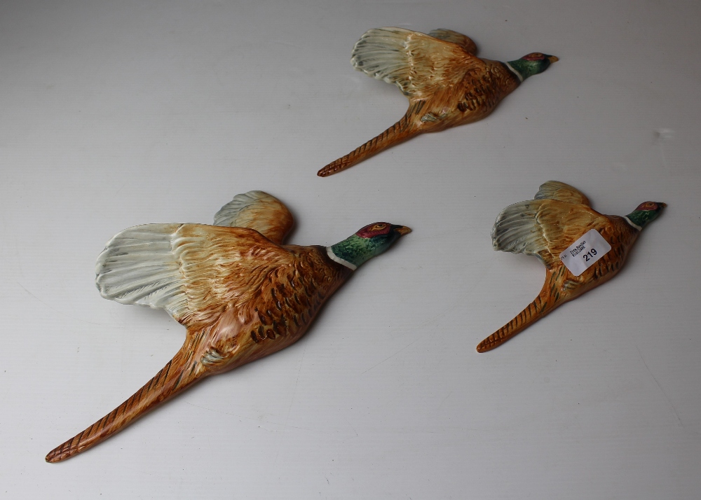 A graduating set of three Beswick pottery 'flying' pheasant wall plaques, models 661/1, 661/2 and