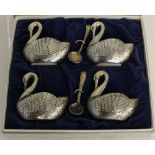 A vintage cased set of four swan form chromed metal salts, with two associated salt spoons, some