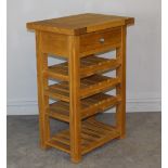 A modern light oak kitchen wine rack, with single drawer over three wine rack tiers and slatted base