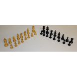 A turned light wood and ebonised wood chess set, thirty two pieces in total, housed in a pine box