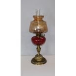 A 20th century 'Duplex' brass oil lamp with, tinted shade, twin adjusters over a cranberry glass