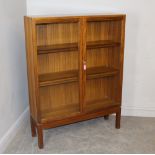 A 1970's glazed teak bookcase with three internal shelves, Military Crows foot mark to reverse 122cm