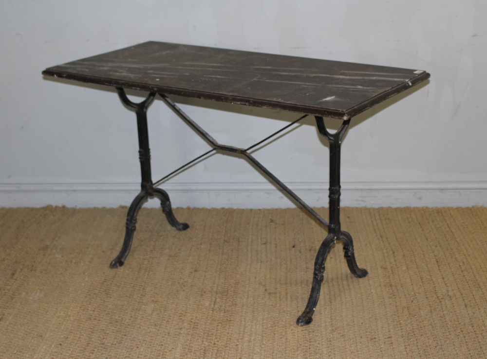 A cast-iron base pub table with moulded rectangular top above scroll cast trestle type supports