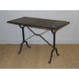 A cast-iron base pub table with moulded rectangular top above scroll cast trestle type supports