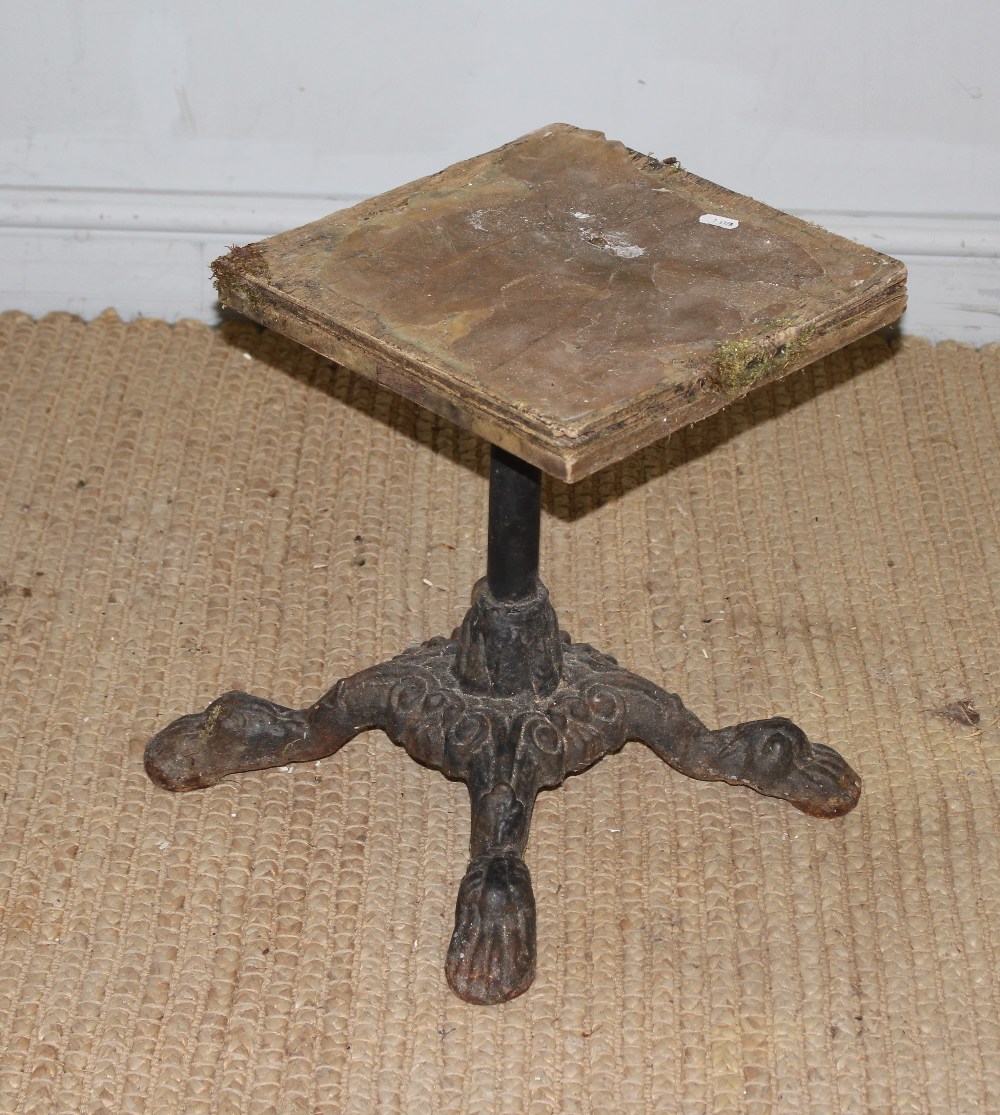 A cast-iron bar stool base with four feet, later top (af) 41cm a degree of corrosion but the base is