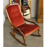 A Victorian mahogany rocking chair, with padded and buttoned back, down-swept open arms and cabriole