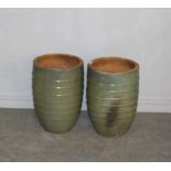 A pair of large green-glazed terracotta garden planters, of ribbed and tapering cylindrical form