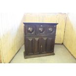 A 19th century dark-stained oak cupboard, of Aesthetic influence, having a moulded cornice with