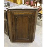 A George III oak corner cupboard, with panelled door 100cm splits to door, losses to mouldings,