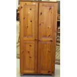 A modern pine double door wardrobe, with double panelled doors and turned feet 179cm x 86.5cm x 51cm