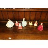 A group of six Royal Doulton figurines and a Royal Worcester Grandmothers Dress figurine, each in