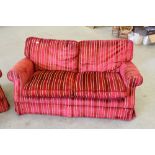 A pair of modern two-seater settees, upholstered in striped red and gold colour material, reportedly