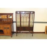 A 1920's mahogany glazed china cabinet, with moulded top above a central glazed door with shaped