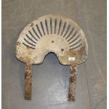 An old tractor seat, 43cm x 60cm, rusted and with concrete residue