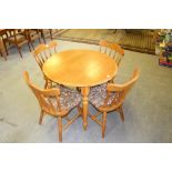 A modern circular beech dining table 74.5cm x 91cm and four spindle back chairs with padded seats