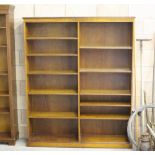 A modern oak bookcase with short dentil moulded frieze above two banks of shelving, on a plinth base