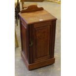 A Victorian mahogany pot cupboard, with shaped ad raised back over the square top and panelled door,