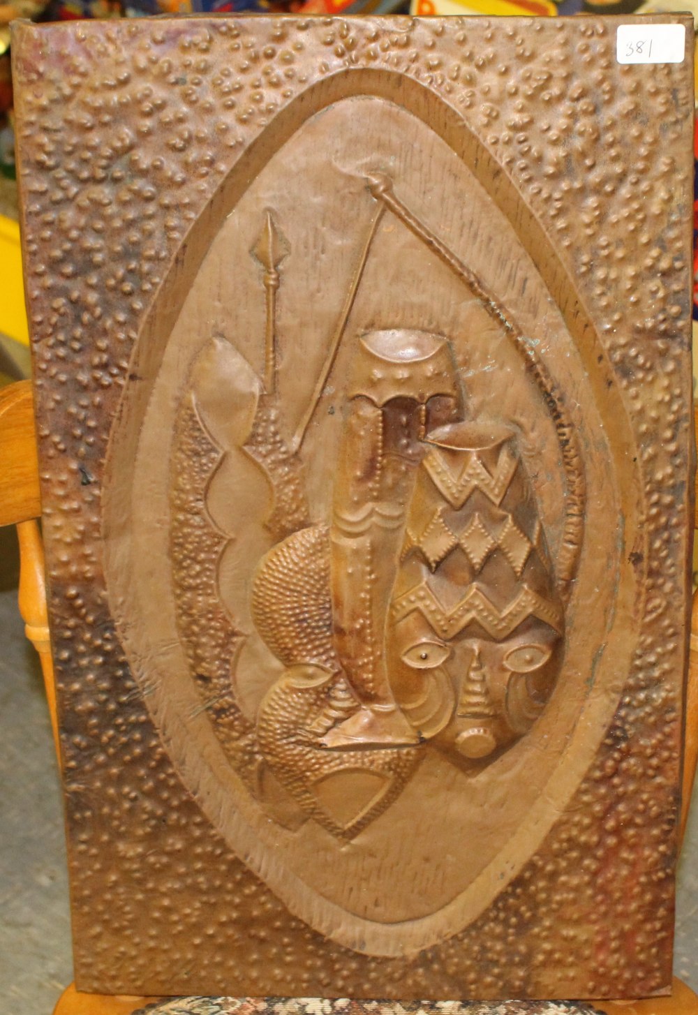 A Zambian embossed copper panel, the central shield-form cartouche decorated with tribal shields and - Image 2 of 2