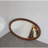 A 1920's moulded oak framed oval wall mirror with bevelled plate 62cm x 104cm minor spotting to