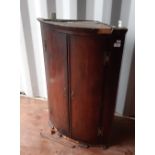 A George III oak and mahogany banded bowfront corner cupboard, fitted three shelves, 65cm wide x