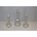 A moulded or pressed glass mallet form decanter 32cm and a pair of smaller glass decanters, 24cm,